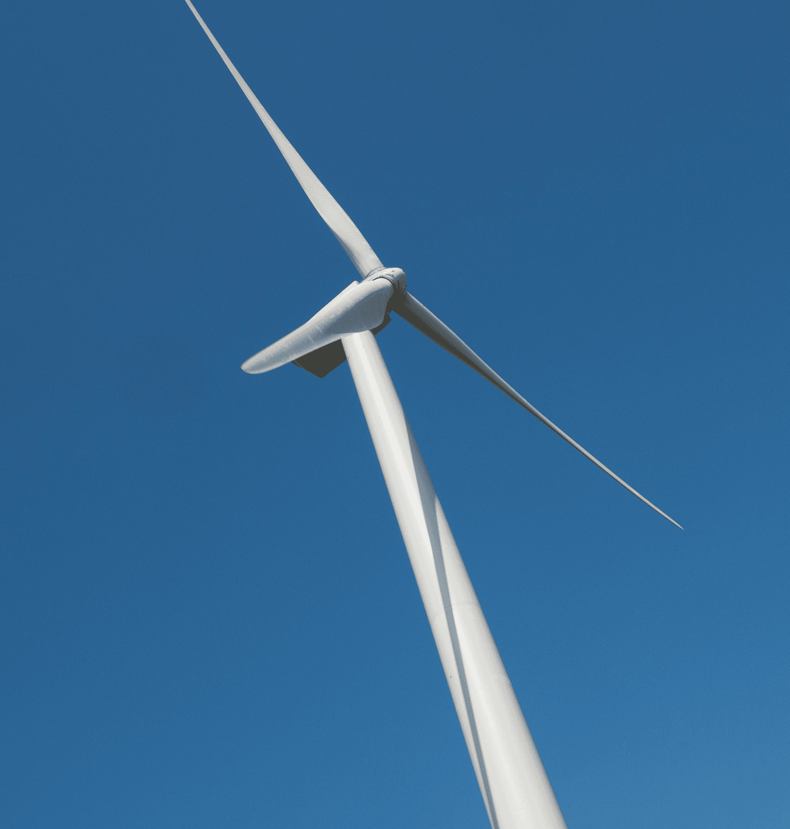 A close-up view of a lcswma wind turbine set against a clear blue sky, illustrating how clean energy and sustainable waste management contribute to a greener future.